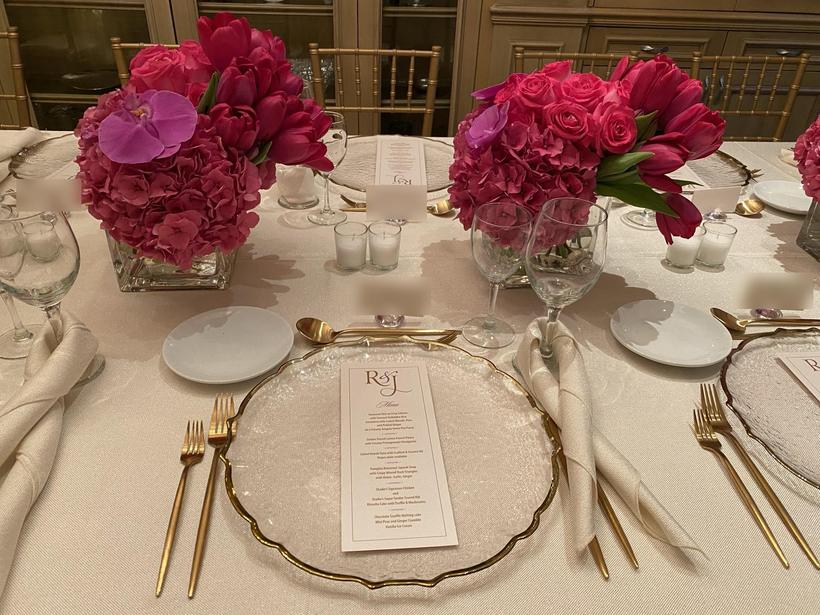 Plated wedding dinner table with gold flatware and printed menu card
