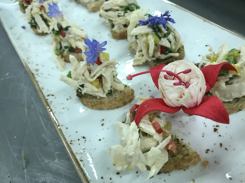 Chicken salad canapés with edible flowers
