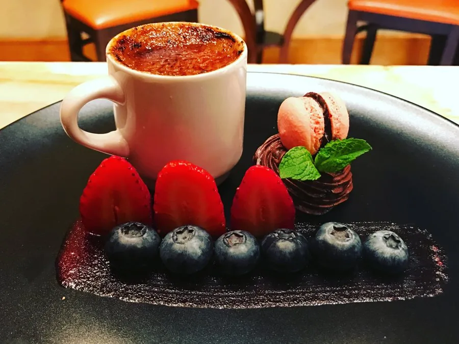 Cr&egrave;me br&ucirc;l&eacute;e with macaron, chocolate meringue nest and berries